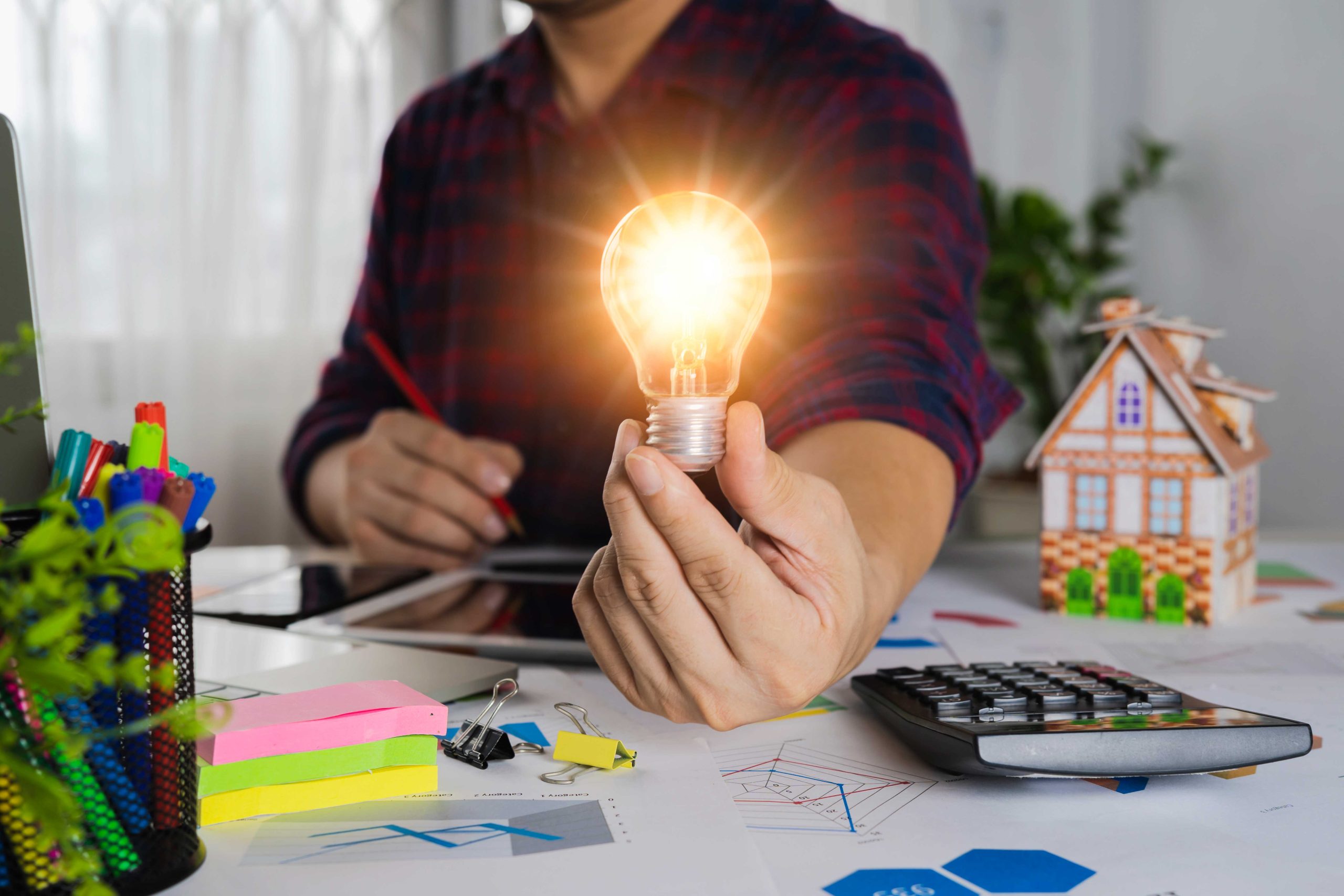 human-hand-holds-light-bulb-presses-calculator-calculate-company-energy-use-numbers