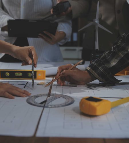 team-multiethnic-architects-working-construction-plans-meeting-room-engineers-discussing-project-office-mature-businessman-woman-standing-around-table-working-blueprint